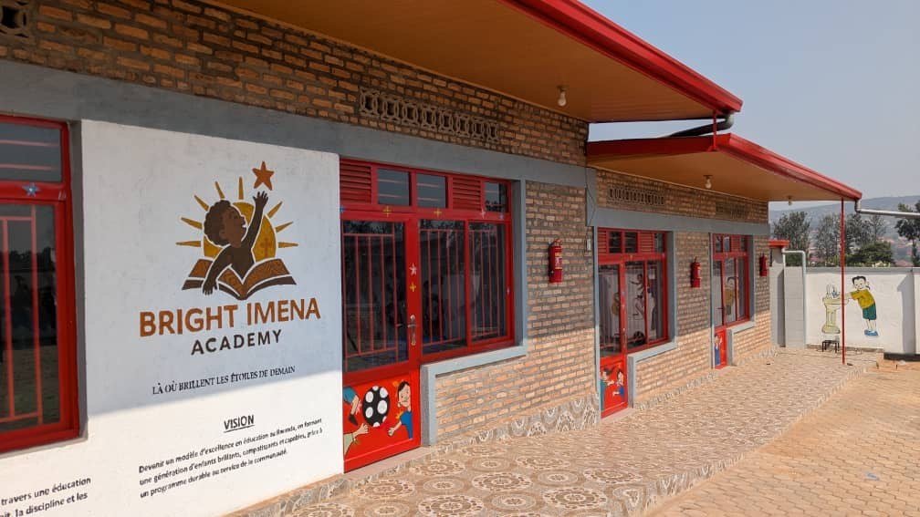 Le b&acirc;timent des classes, avec le logo et la vision de Bright IMENA Academy peints sur le mur